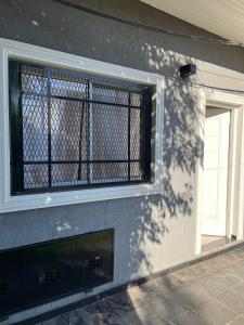 ein Fenster an der Seite eines Gebäudes mit einem Kamin in der Unterkunft DaniyMari in Monte Grande