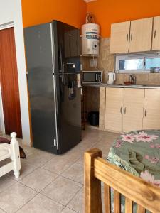 eine Küche mit einem schwarzen Kühlschrank im Zimmer in der Unterkunft DaniyMari in Monte Grande