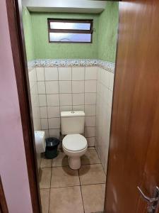 ein kleines Badezimmer mit Toilette und Fenster in der Unterkunft Novo Mundo Hotel in Barra do Garças