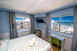 a bedroom with a bed and a view of the ocean at Hotel Playa Brava in Punta del Este