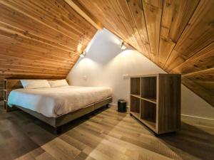 Les Cottages de Ripaille في تونو لي بان: غرفة نوم بها سرير وسقف خشبي