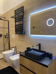 a bathroom with a black sink and a toilet at Mado Suite 112 in Bari +29 photos