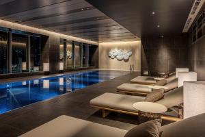 a swimming pool with lounge chairs in a hotel lobby at InterContinental Sapporo by IHG in Sapporo