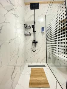 un bagno con doccia con pareti in marmo bianco di Catunu lupului village Cabana Monte Benito a Cotorăşti Altre 65 foto