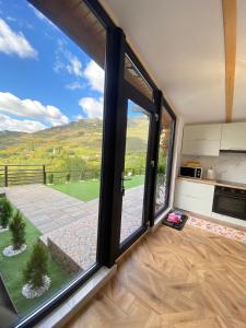 una stanza con una grande finestra con vista sulla cucina di Catunu lupului village Cabana Monte Benito a Cotorăşti