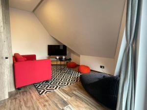 a living room with a red couch and a tv at Diamond Magic 2 Divcibare in Divčibare