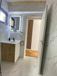 un bagno con lavandino e specchio di Catunu lupului village Cabana Monte Benito a Cotorăşti