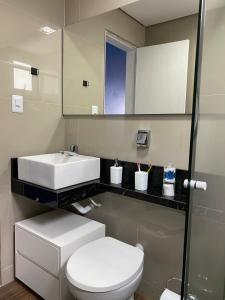 a bathroom with a white toilet and a sink at Congresso ou maratona, studio central, com garagem in Florianópolis