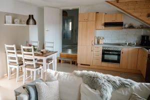 a living room with a couch and a kitchen with a table at Ferienwohnung Landliebe in Pfullendorf