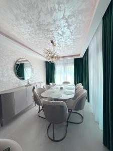 ein Esszimmer mit Tisch und Stühlen in der Unterkunft Royal Residence in Moşniţa Nouă