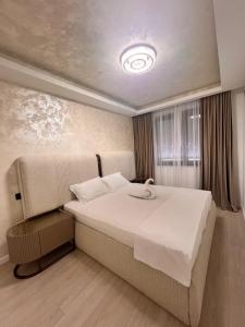 ein Schlafzimmer mit einem großen weißen Bett in einem Zimmer in der Unterkunft Royal Residence in Moşniţa Nouă