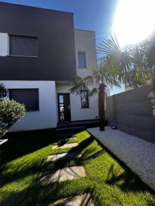 ein Haus mit einer Palme davor in der Unterkunft Royal Residence in Moşniţa Nouă