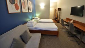 布达厄尔什Varga-ház panzió的一间有两张床、一张桌子和一台电视的酒店房间