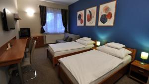 布达厄尔什Varga-ház panzió的有两张床和一张书桌的酒店房间