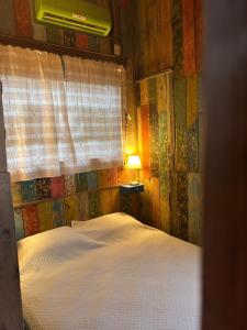 a bedroom with a bed with a window and a lamp at La mar in La Pedrera