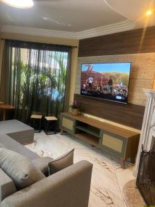 a living room with a large flat screen tv at Casa ao mar -Pousada Itapema in Itapema