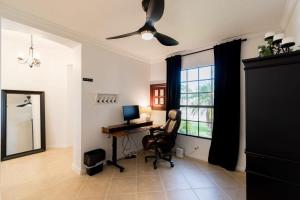 Zimmer mit einem Schreibtisch, einem Computer und einem Deckenventilator. in der Unterkunft Newer 3 Bed 2Bath Home-Near USSSA Complex and Beach in Rockledge