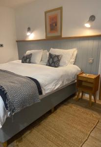 a bedroom with a large bed with white sheets and pillows at Rhubarb Barn bedroom only in Diss