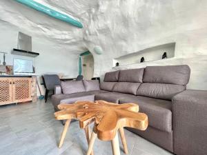 a living room with a couch and a table at Cave Houses Ed, Yara and Nadieh with PRM facilities in Margen de Abajo