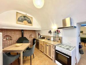 a kitchen with a table and a stove top oven at Cave Houses Ed, Yara and Nadieh with PRM facilities in Margen de Abajo
