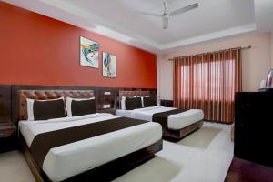 two beds in a hotel room with red walls at Collection O Haridwar Railway Station Formerly Le Central in Haridwār +27 photos