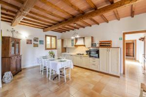 a kitchen with a table with chairs and a kitchen with at Casa Febea in Chiusi +19 photos