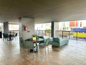 a room with a balcony with tables and chairs at Solaz Smart Living by 123Quarto in Tambaú