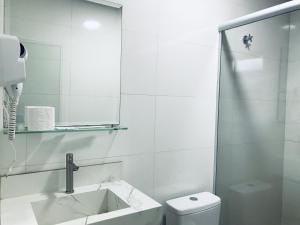 Un baño blanco con lavabo e inodoro. en Hotel Pinheiros - 8 Min do Transamérica Expo Center e 18 Min Autódromo Interlagos, en São Paulo