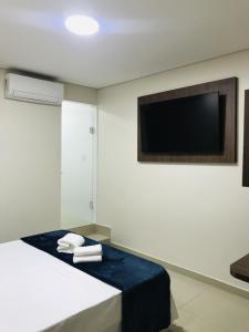 Habitación con 1 cama con toallas y TV de pantalla plana. en Hotel Pinheiros - 8 Min do Transamérica Expo Center e 18 Min Autódromo Interlagos, en São Paulo
