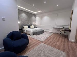 a bedroom with a bed and a blue chair at HavenHomes 1 bedroom Apartment in Ikuata
