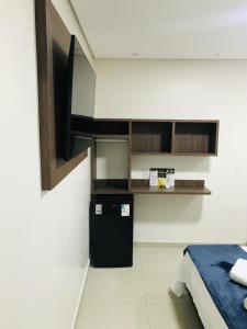 Habitación con nevera pequeña y TV en la pared. en Hotel Pinheiros - 8 Min do Transamérica Expo Center e 18 Min Autódromo Interlagos, en São Paulo 8 fotos más