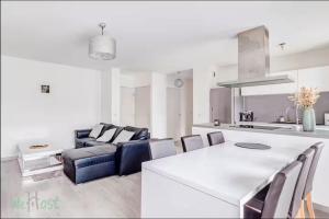 Perollier - CI - Lyon 2 - Bedroom apartment with balcony and pool في إيكولي: مطبخ وغرفة معيشة مع أريكة وطاولة