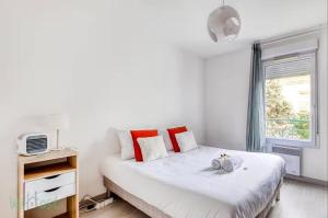 Perollier - CI - Lyon 2 - Bedroom apartment with balcony and pool في إيكولي: غرفة نوم بها سرير مع وسائد حمراء ونافذة
