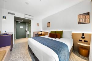 a bedroom with a large bed and a bathroom at Urban Rest Hackney Hotel in North Adelaide