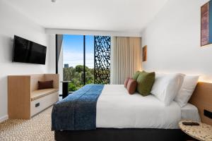 a hotel room with a bed and a large window at Urban Rest Hackney Hotel in North Adelaide
