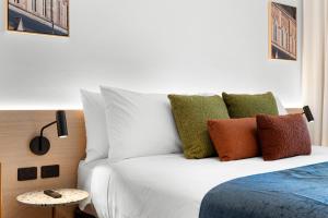 a bedroom with a white bed with colorful pillows at Urban Rest Hackney Hotel in North Adelaide +26 photos