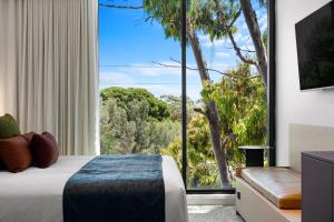 a bedroom with a bed and a large window at Urban Rest Hackney Hotel in North Adelaide