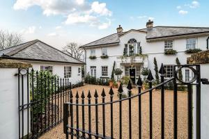 巴斯The Coach House at The Grange的带有黑色栅栏的白色房子