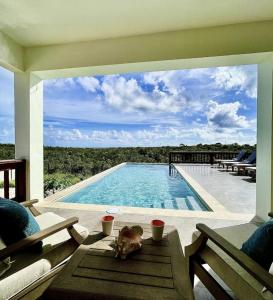 a dog laying on a table next to a swimming pool at Zirok Villas in The Valley