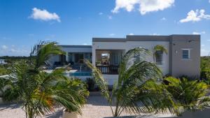 a house with palm trees in front of it at Zirok Villas in The Valley