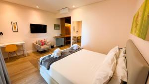 a bedroom with a bed and a living room at Pousada Girassol in Bonito