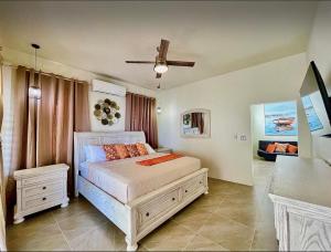 a bedroom with a bed and a ceiling fan at Zirok Villas in The Valley +39 photos