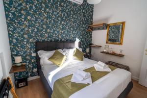 1 dormitorio con 1 cama grande y papel pintado con motivos florales en NOI Luxury rooms Colosseum, en Roma