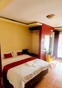 a bedroom with a large bed with red and yellow walls at STERLEON HOTEL RIVERSIDE in Nairobi
