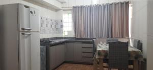 a kitchen with a refrigerator and a table and chairs at Recanto da Lagoa in Passo de Torres