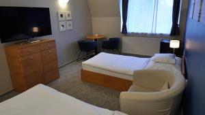 a hotel room with two beds and a tv at Varga-ház panzió in Budaörs