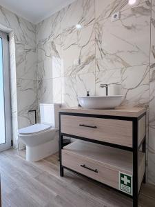a bathroom with a sink and a toilet at Figueira Guesthouse in Figueira da Foz