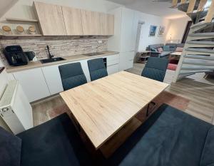 Una cocina y una sala de estar con una mesa y sillas de madera. en Tatra Family Loft, en Vysoké Tatry 11 fotos más