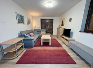 una sala de estar con un sofá y una mesa en Tatra Family Loft, en Vysoké Tatry