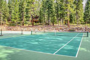 een tennisbaan met bomen op de achtergrond bij Kings Beach Luxe in Wood Vista